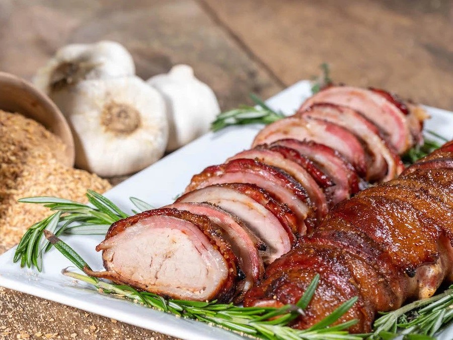 Bacon wrap Tenderloin sliced next to herbs, spices and garlic