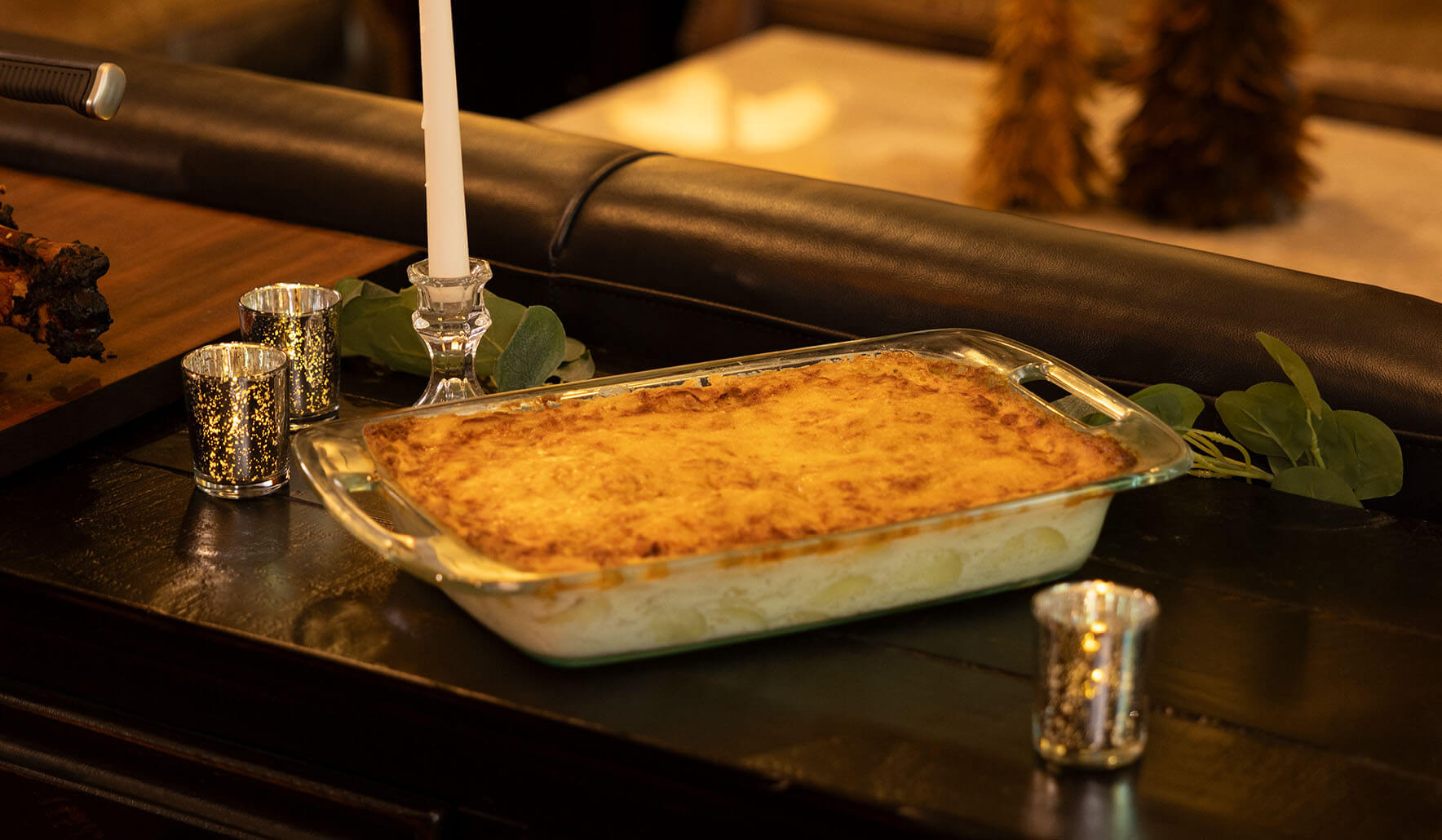 cheesy smoked potato casserole on holiday table with candle