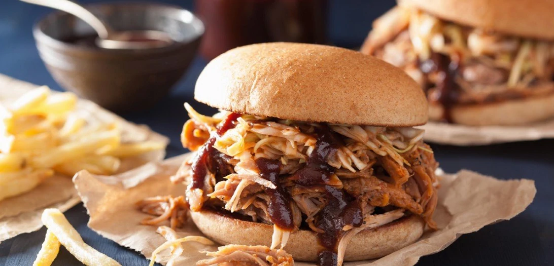 close up of pork slider with cole slaw and bbq sauce