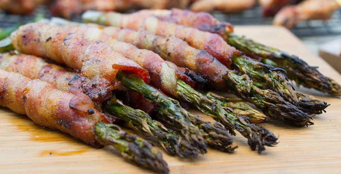 bacon-wrapped asparagus on wood board