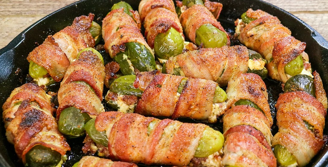bacon wrapped stuffed pickles in cast iron pan