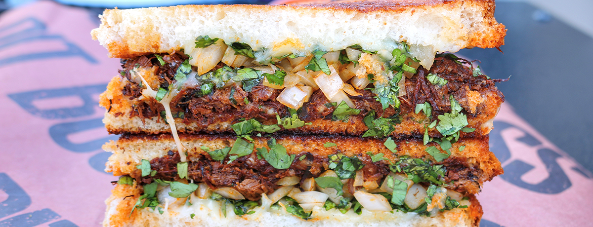 Birria sandwich with onion and cilantro