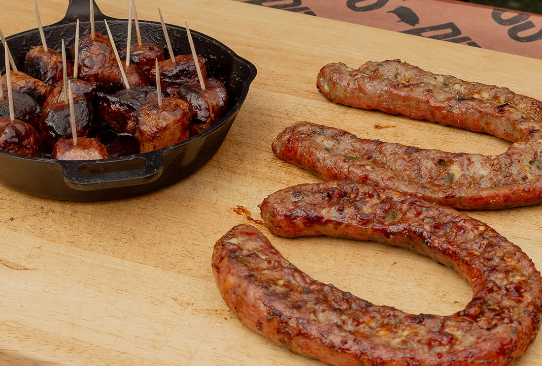 smoked sausage cooked on the pit boss wood pellet grill made by pitmaster erica blaire with cast iron and bbq sauce