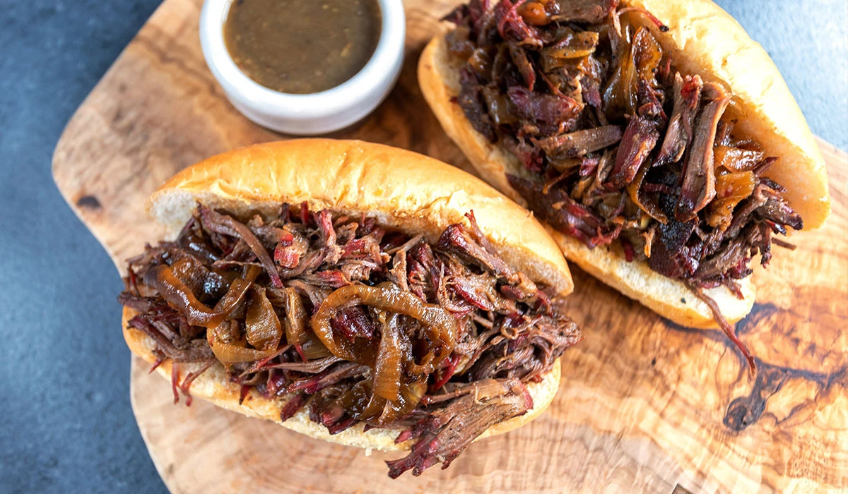 2 Shredded Beef sandwiches on wood cutting board