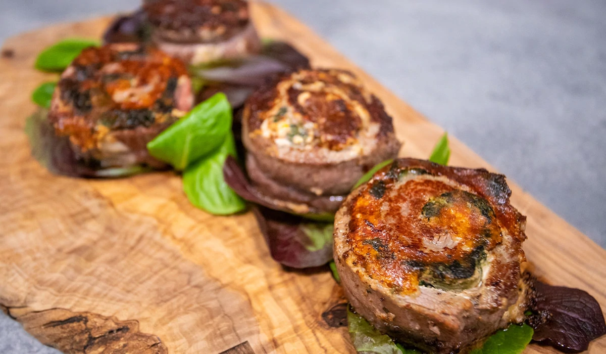 tasty looking Cheesy Stuffed Steak on wooden cutting board