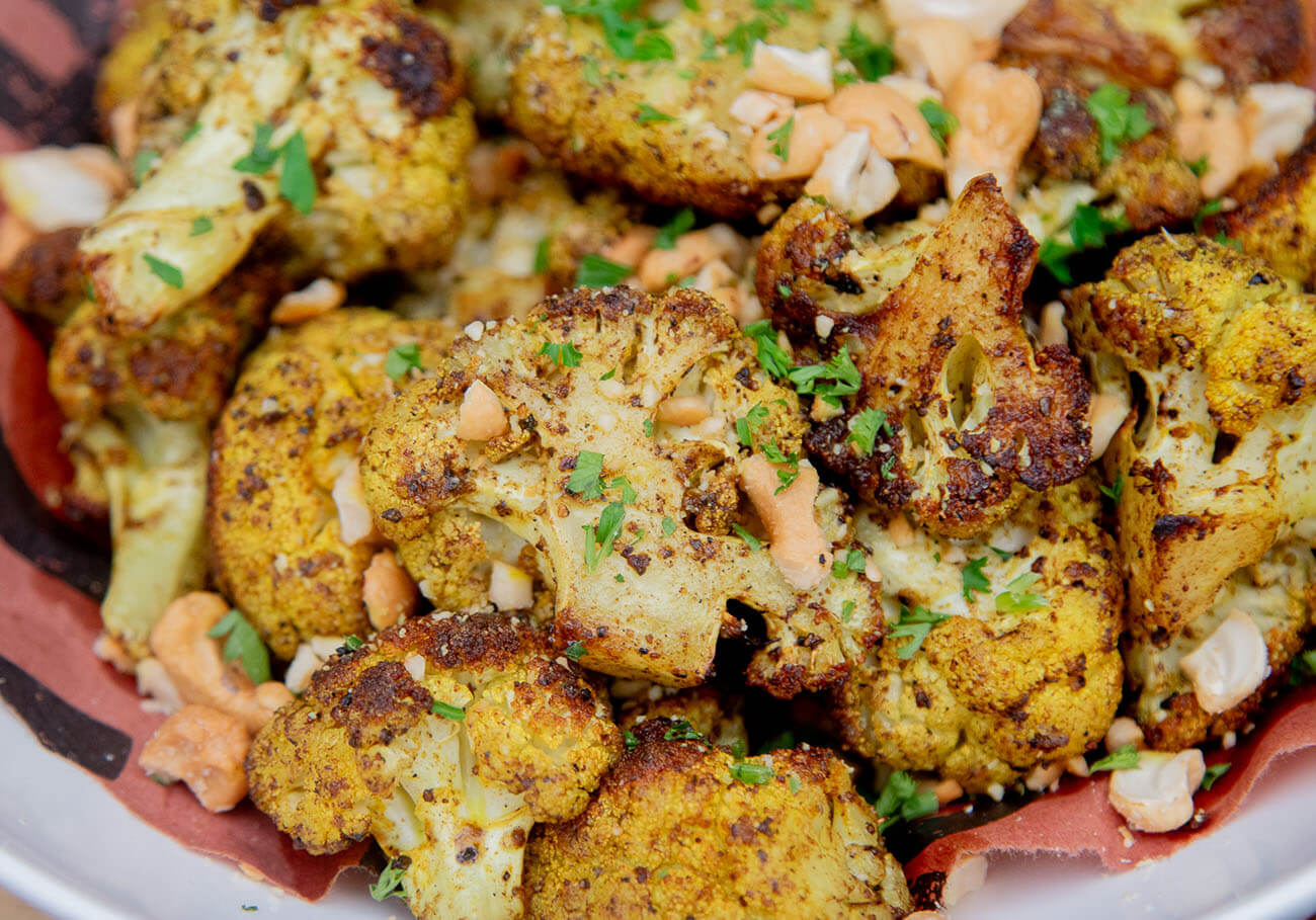 roasted cauliflower with yellow curry and brown butter sauce, chopped cashews, and parsley