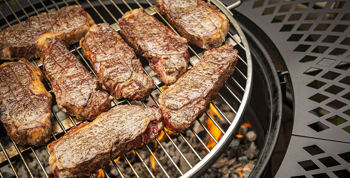 seared ny strip steaks cooked over a pit boss fire pit open fire searing campfire backyard recipe