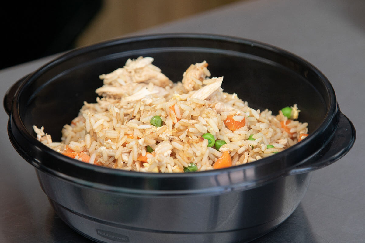 chicken fried rice cooked on griddle in meal prep containers