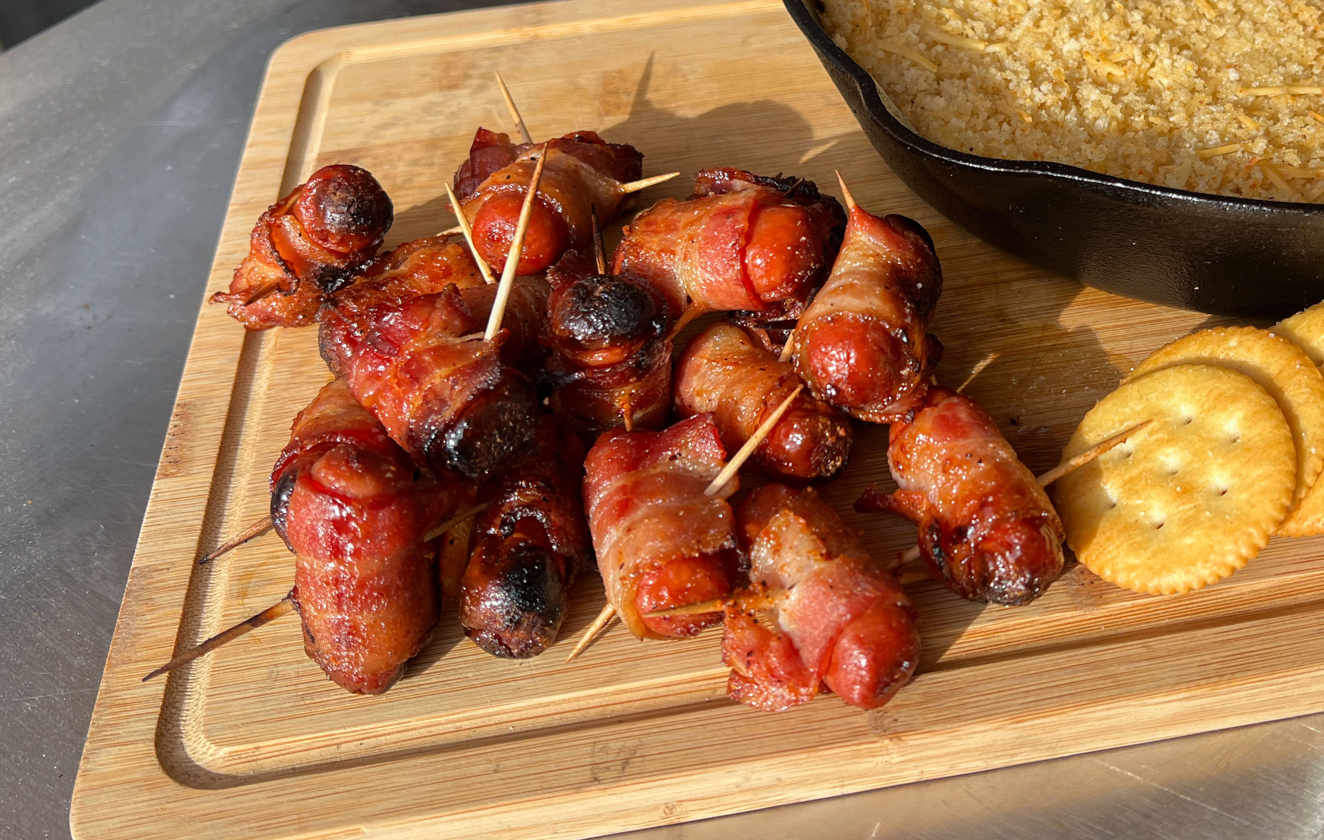 smoked bacon-wrapped weenies on a cutting board with toothpicks