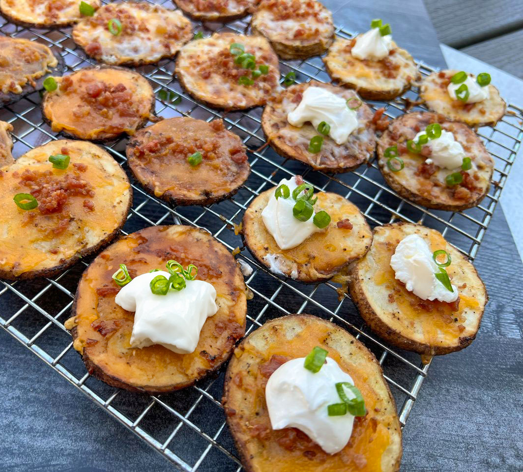 crispy grilled potato skins cooked on pit boss wood pellet grill topped with sour cream and green onions