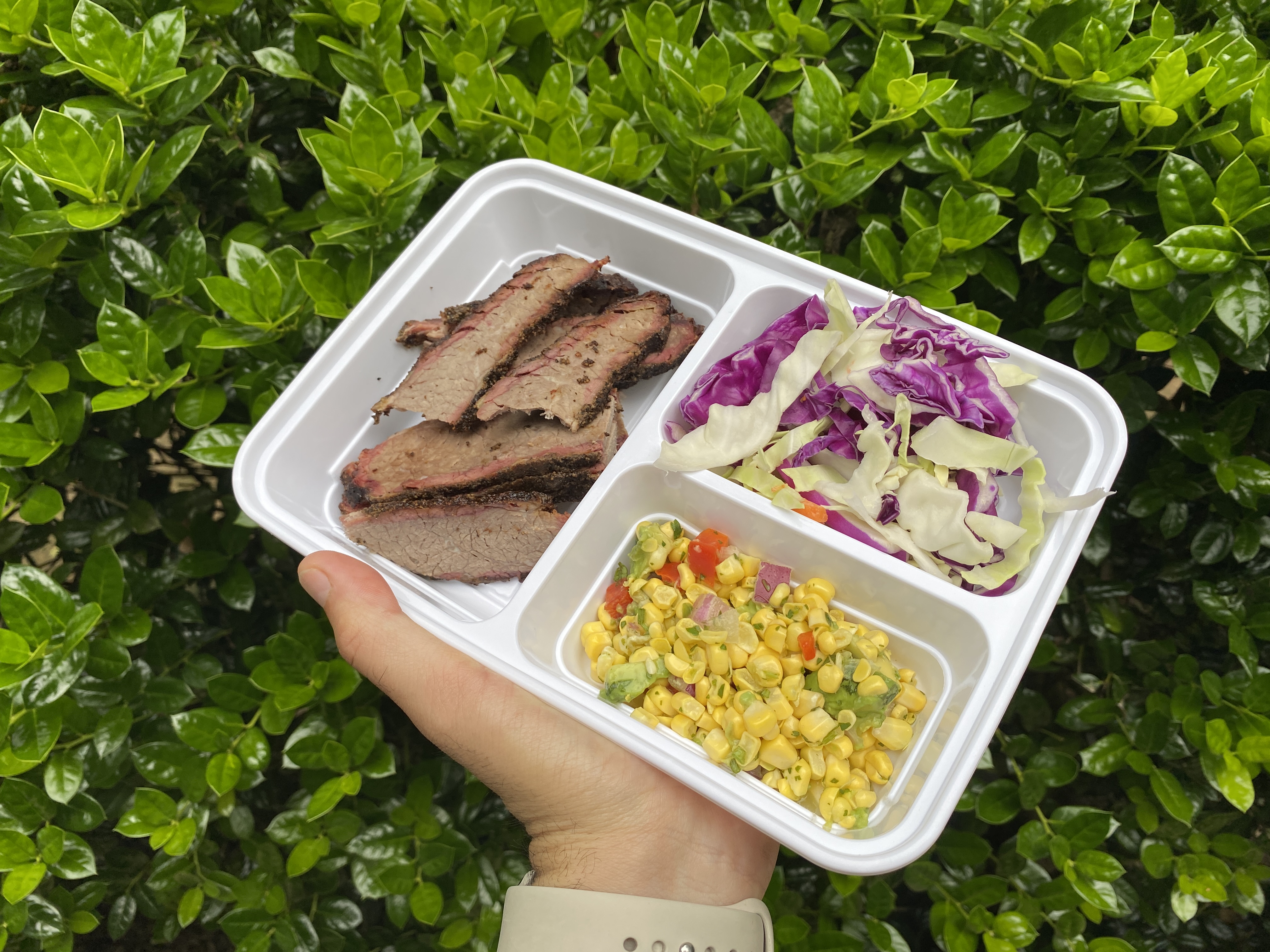 vibrant veggies and sliced brisket in meal prep container