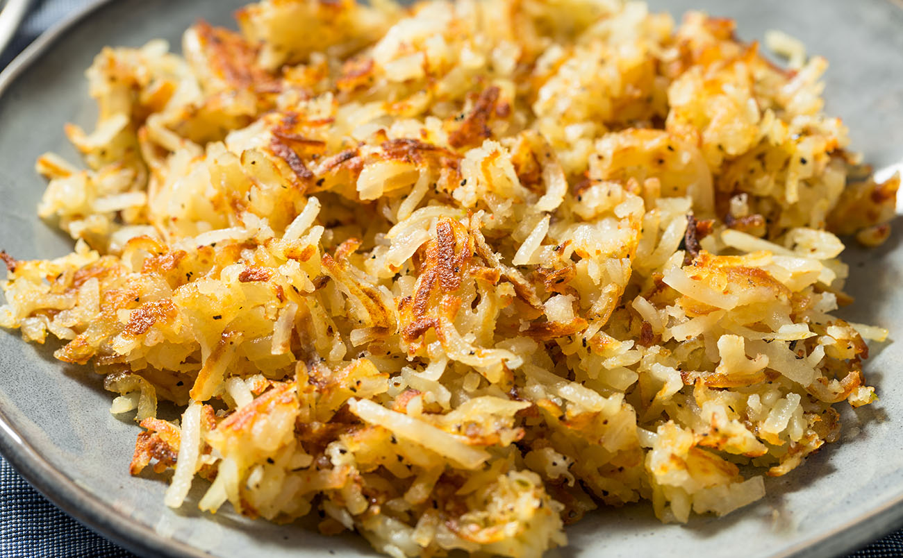 griddle cooked hashbrowns on grey plate cooked on pit boss flat top gas griddle