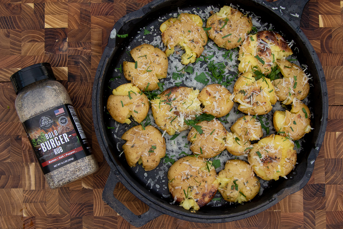 Parmesan Crusted Potatoes on cast iron skillet with Pit Boss Burger bold Rub