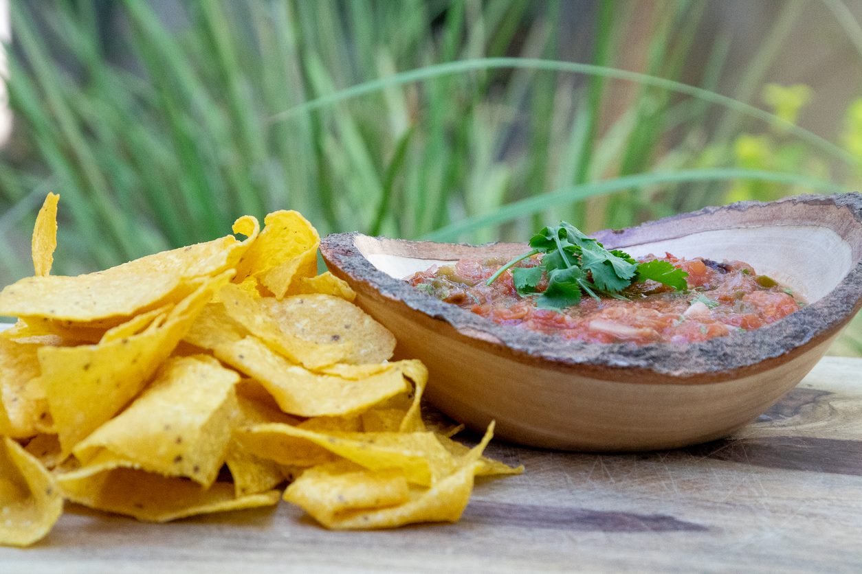 smoked salsa cooked on pit boss hardwood pellet grill in wooden bowl next to tortilla chips