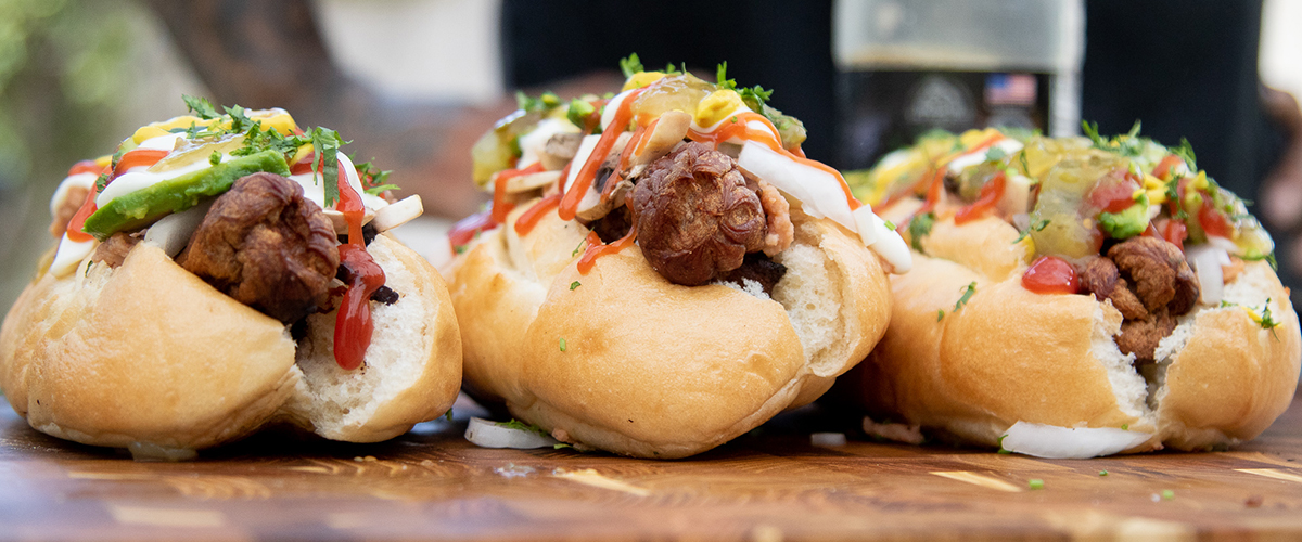 Delicious Sonoran hot dogs topped with avocado, onion, and ketchup