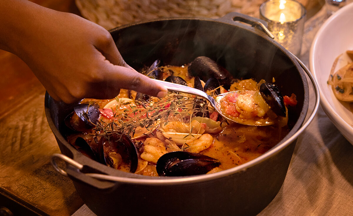 smoked seafood cioppino in pit boss cast iron camp oven on holiday table