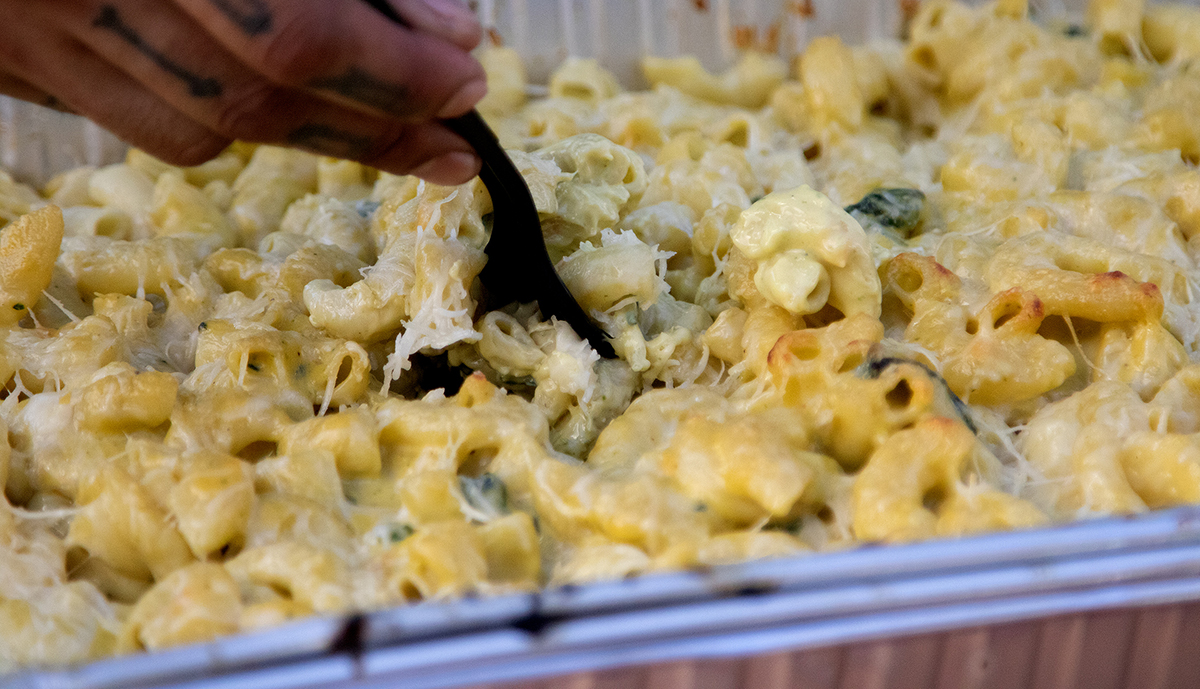 delicious pesto mac n cheese cooked on a pit boss wood pellet grill in aluminum foil pan