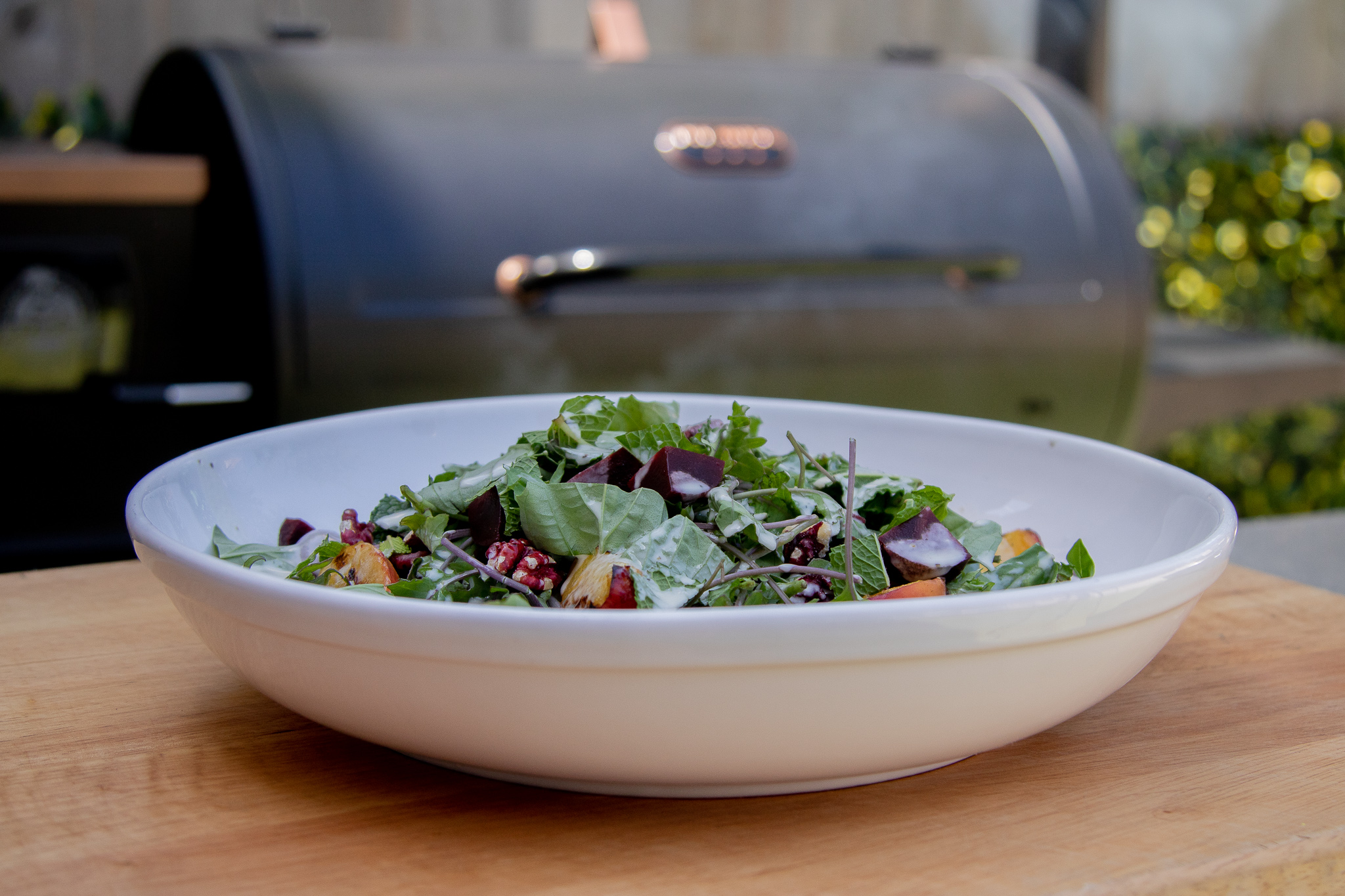 grilled salad in bowl in front of a Pit Boss Savannah Onyx Wood Pellet Grill
